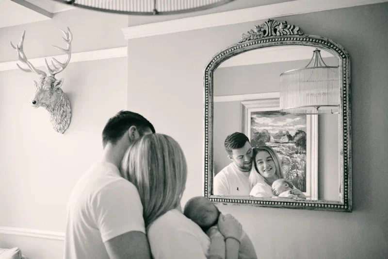 Parents cuddling newborn at home, lifestyle newborn photography in Jesmond